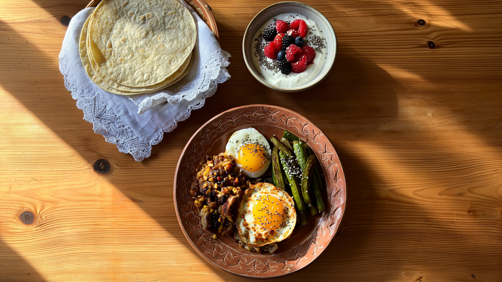 Plato de huevos a la mexicana con nopales y frijoles junto a yogur con frutos rojos