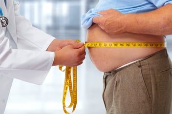 Persona midiéndose el abdomen para ver su nivel de grasa